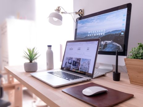 MacBook Pro on table beside white iMac and Magic Mouse