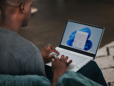 man in gray long sleeve shirt using Windows 11 computer