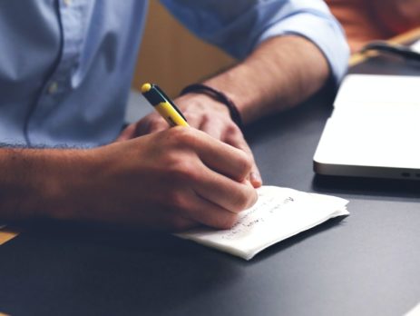 Free Person Writing on Paper Using Yellow and Black Pen Stock Photo