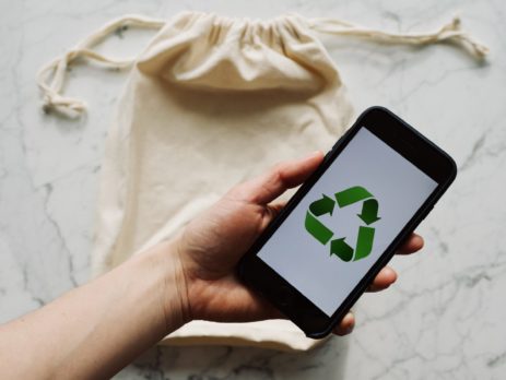 Free Faceless person showing recycle symbol on mobile phone screen Stock Photo